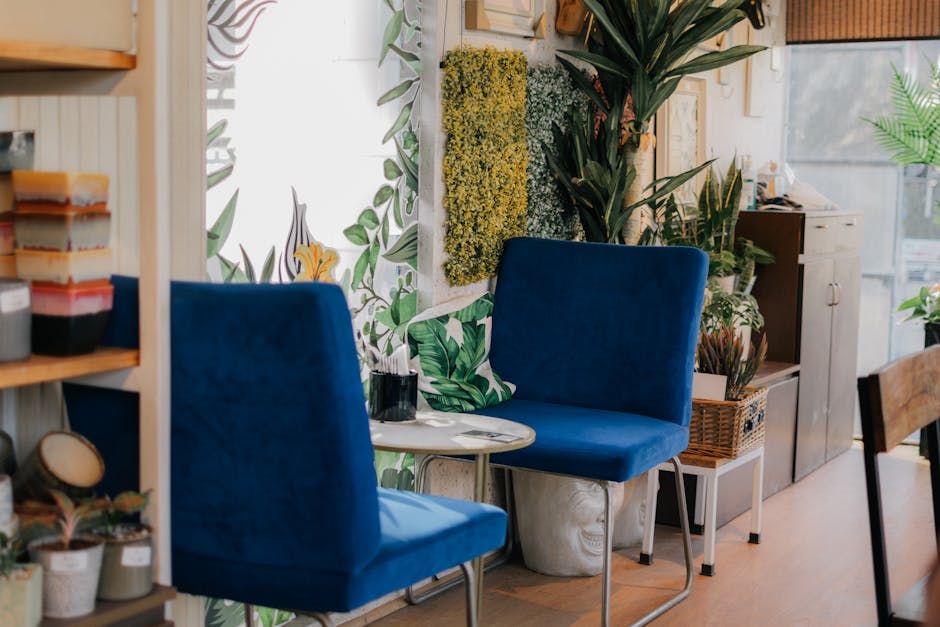 Inviting indoor space with vibrant blue chairs, lush houseplants, and a small coffee table.