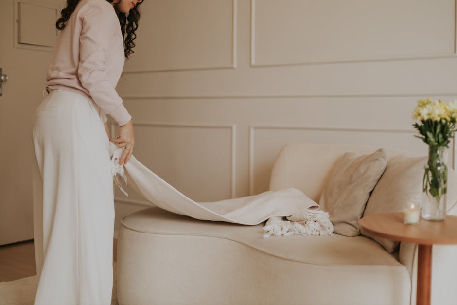 Elegant minimalist living room with soft tones, showcasing a cozy setting and feminine aesthetic.