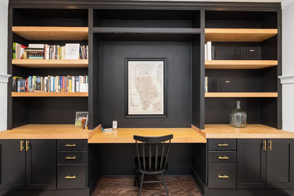 Sleek black and wood office setup with bookshelves and a desk creating a sophisticated workspace.