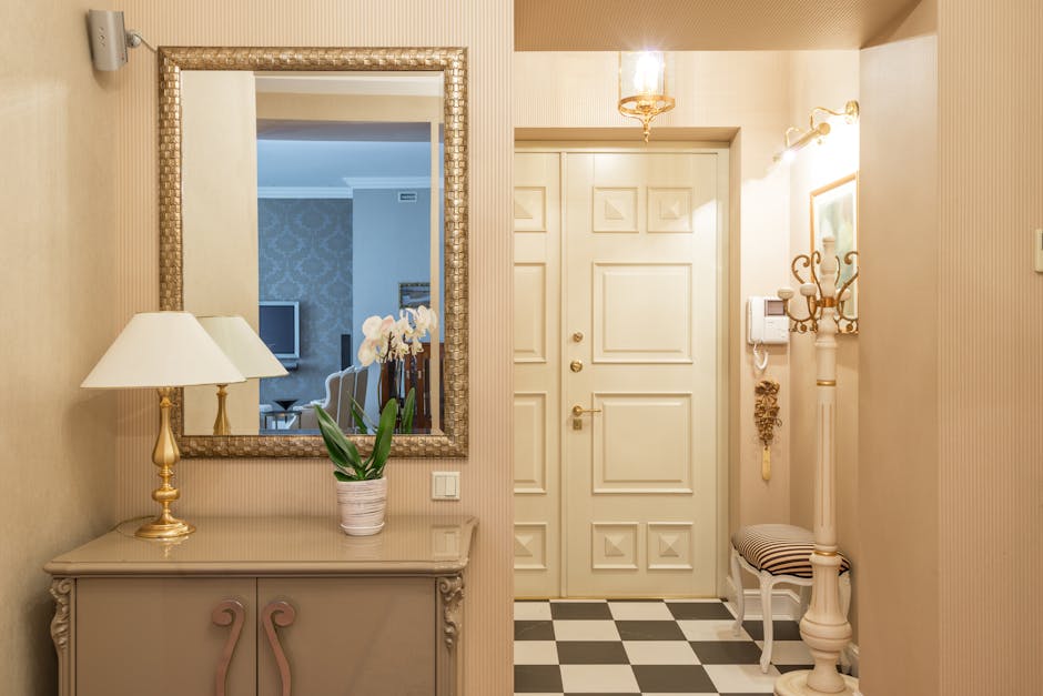 A beautifully styled entrance hall with a mirror, lamp, and potted orchid emphasizes classic decor.