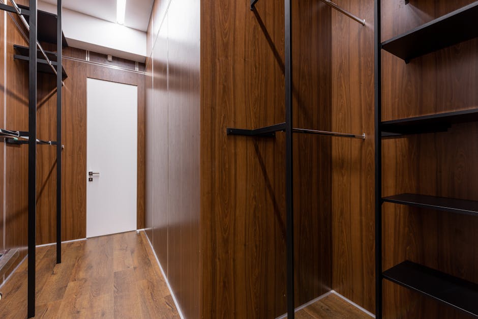 Spacious modern walk-in closet featuring wooden walls and shelving units.
