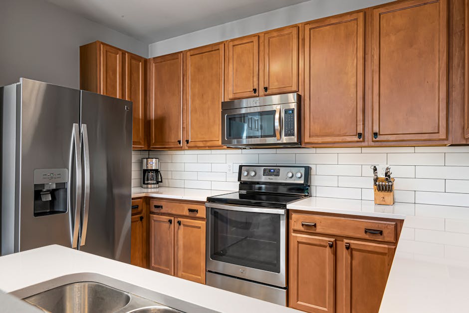 Elegant kitchen featuring stainless steel appliances and wooden cabinets with white subway tile backsplash.