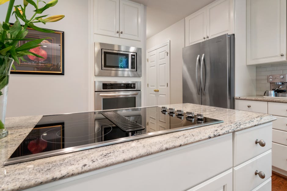 Sleek kitchen interior featuring stainless steel appliances and spacious granite countertop, ideal for modern living.