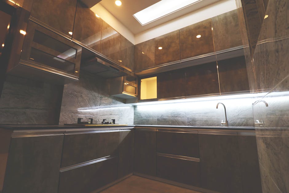 Stylish modern kitchen with sleek cabinets and ambient lighting, showcasing contemporary design.