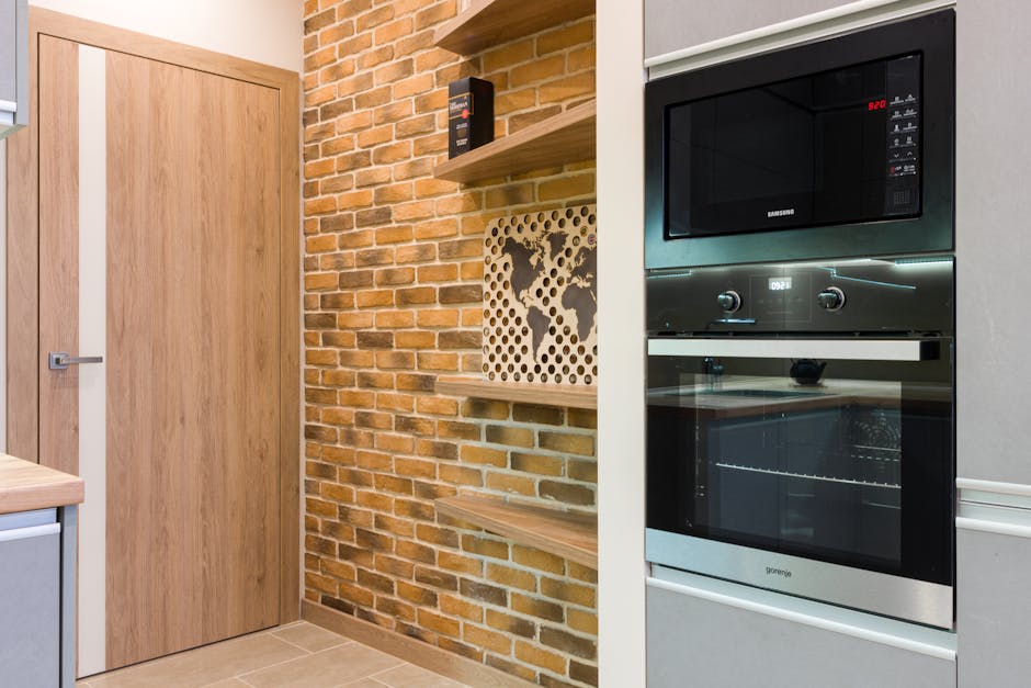 Stylish interior kitchen featuring a brick wall and modern appliances.
