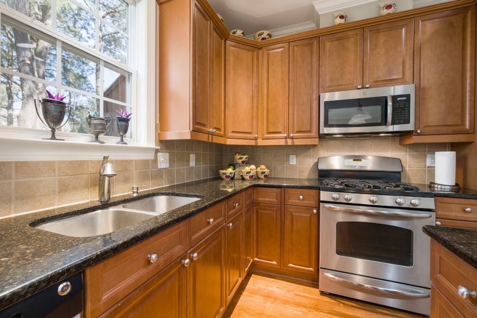 A well-lit modern kitchen featuring wooden cabinets and stainless steel appliances.