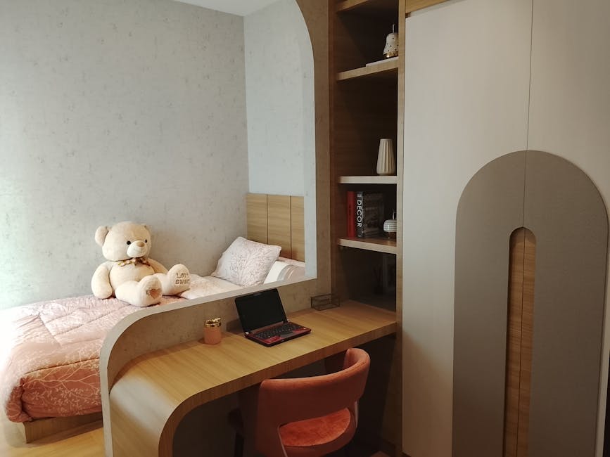 Warm and inviting modern bedroom with a cozy bed, teddy bear, and compact desk area.