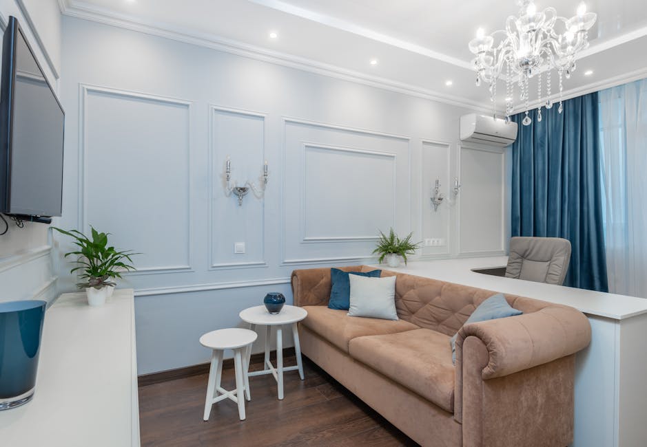 Bright and elegant living room featuring a chandelier, plush couch, and stylish decor.