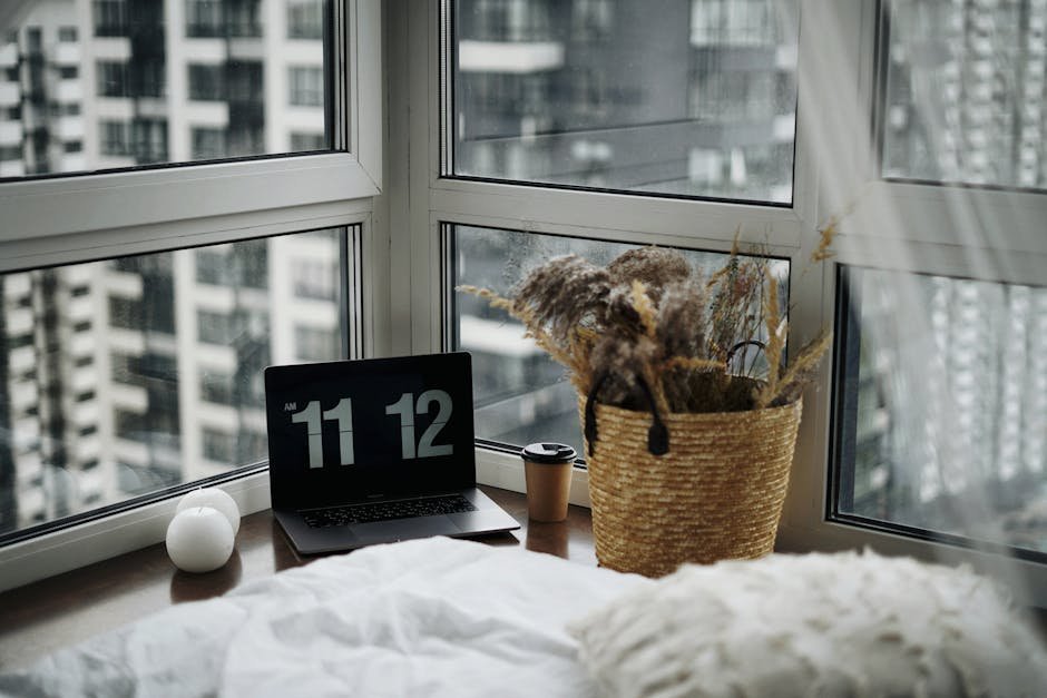 A minimalist workspace with a laptop in a cozy Kyiv apartment featuring large windows and city views.