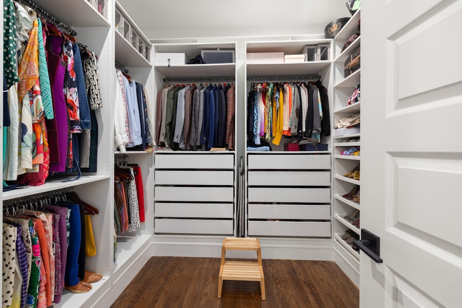 A neatly arranged walk-in closet showcasing a colorful variety of clothes and shoes.