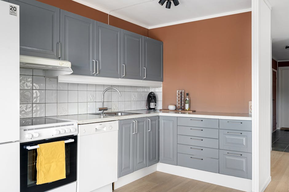 Chic minimalist kitchen interior featuring gray cabinets and modern appliances.