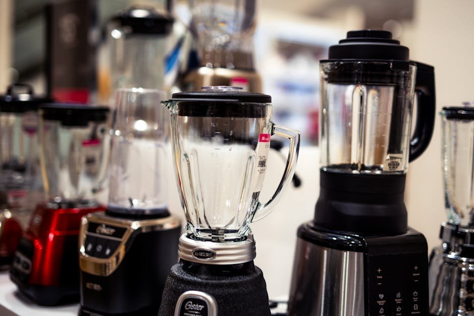 A variety of kitchen blenders displayed on a showroom countertop.
