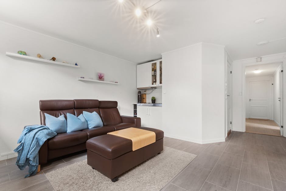 Wide-angle view of a modern living room with a brown leather sofa and sleek furnishings.