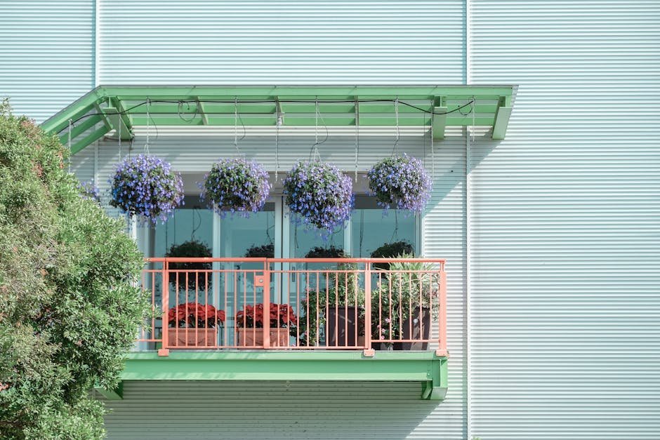 A vibrant balcony adorned with hanging purple flowers and potted plants, adding charm to a modern facade.