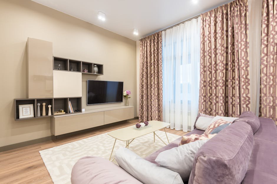 Comfortable sofa with cushions and coffee table placed in front of cabinet and modern TV set in cozy apartment