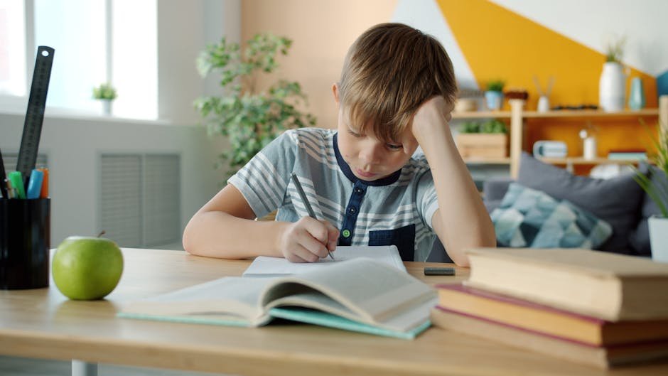 Young boy concentrating on homework at desk in a colorful room.