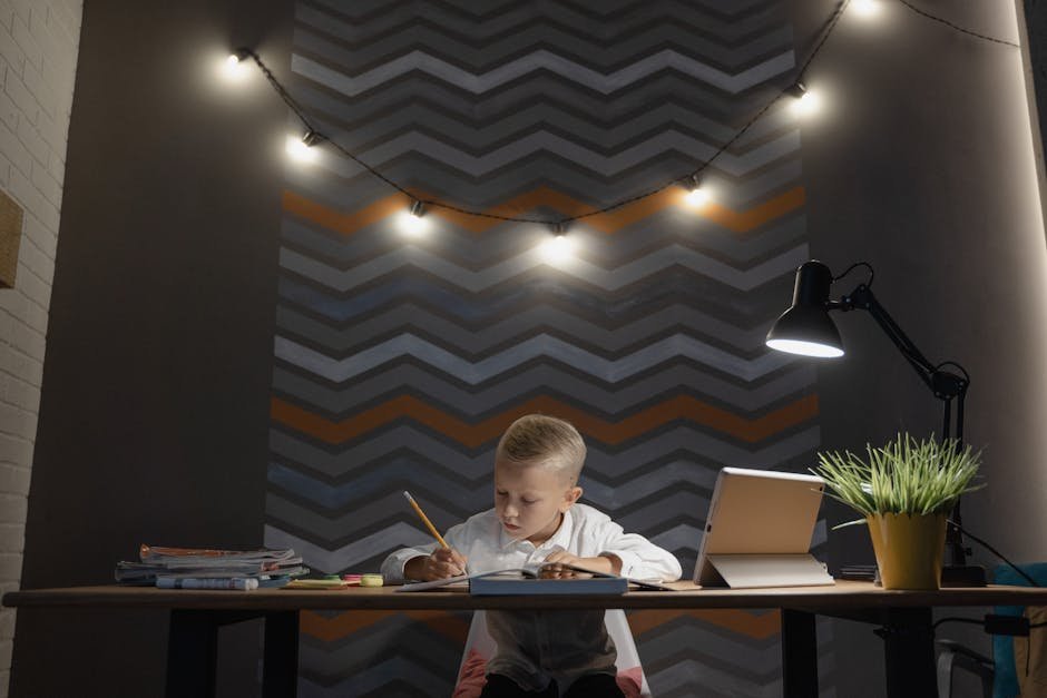 A young boy diligently studying at a desk with string lights and zigzag wallpaper.