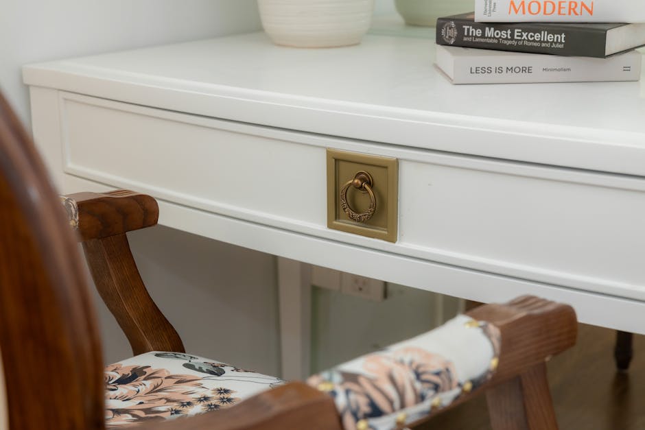 Stylish white desk with floral chair and modern books creating a cozy study nook.
