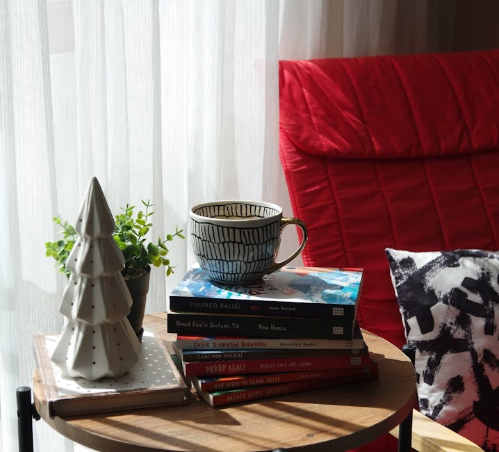 A cozy indoor scene with a mug, stack of books, and decorative items by a window, perfect for relaxation.