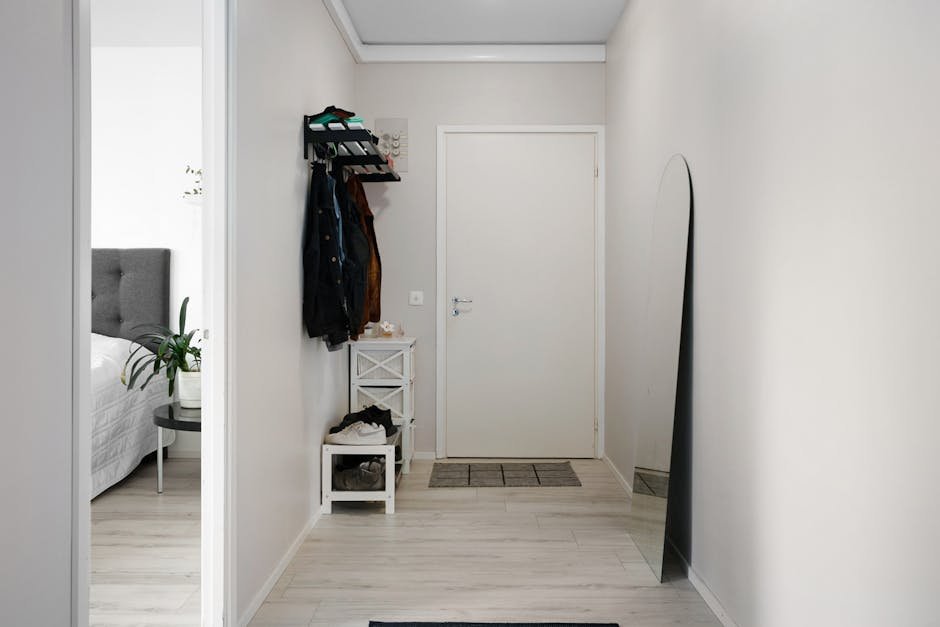 A minimalist hallway with white walls, modern decor, and simple furnishings.