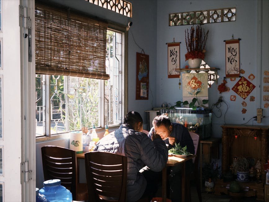 Warm, intimate scene of two people dining in an Asian-style room with traditional decor.