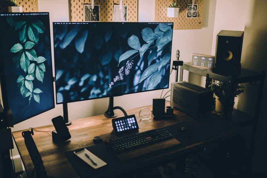 Stylish and functional home office with dual monitors, keyboard, and sound system, perfect for productivity and creativity.